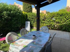 a blue table and chairs on a patio at Charmante maisonnette proche plage in Cap d'Agde