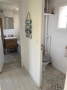 a bathroom with a toilet and a sink at Charmante maisonnette proche plage in Cap d'Agde
