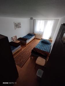 a living room with two beds and a window at Planinski dom Vrhe in Trbovlje +5 photos