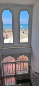 two windows in a room with a view of the beach at Apartamento Don Manuel in Rincón de la Victoria