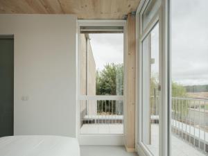 a bedroom with a door open to a balcony at Hotel Amiuka in O Pedrouzo