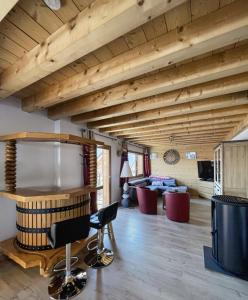 uma sala de estar com um tecto de madeira com vigas em Chalet la Cochette em La Toussuire
