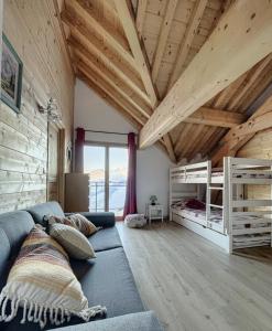 a living room with a couch and a bed at Chalet la Cochette in Fontcouverte