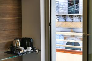 a door leading into a room with a coffee maker on a shelf at El Concept Room in Brolo