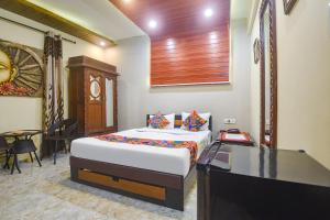 a bedroom with a bed and a desk and a television at Via Corinthia Boutique Rooms - Nr Candolim Beach in Candolim