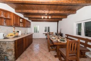 a kitchen with a table and some chairs and a counter at Country House Dumančić with nice garden and hot tub in Lovreć