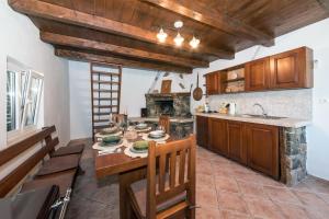 una cocina con armarios de madera y una mesa en una habitación en Country House Dumančić with nice garden and hot tub, en Lovreć