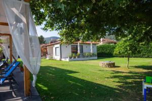 un cortile con una casa e un albero di Villa Vasiliadi a Vourvourou