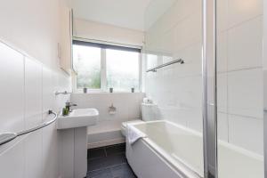 Baño blanco con bañera y lavamanos en Stunning 2 Bedroom Apartments in Birmingham en Birmingham