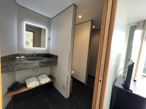 La salle de bains est pourvue d'un lavabo et d'un miroir. dans l'établissement Villa l’écrin du Rayol, à Rayol-Canadel-sur-Mer