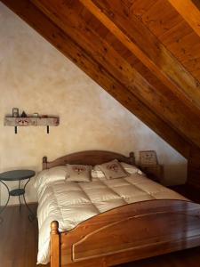 - une chambre mansardée avec un lit et une table dans l'établissement Chalet Montana - Borgo Le stalle Lunghe, à Prato Nevoso