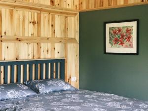 - une chambre avec un lit aux murs verts et une photo dans l'établissement Ta Phin Cottage, à Sa Pa