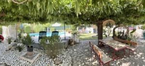 un patio avec une table et des chaises sous un arbre dans l'établissement La Romantica, à Congéniès