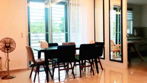 stół i krzesła w pokoju z oknami w obiekcie Impiana Lakeview Villa - Contactless Check In w mieście Kluang