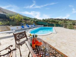 レアルモンテにあるRavishing Villa in Realmonte with Private Swimming Poolのスイミングプールの横のテーブルと椅子