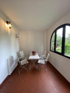 a room with a table and chairs and a window at La casa del nonno Franco in Colico