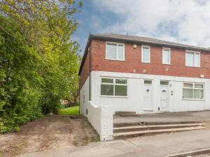 a brick house with a white garage at Spacious Retreat near city centre Pass the Keys in Leeds