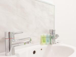 a white bathroom sink with a mirror and a sink at Spacious Retreat near city centre Pass the Keys in Leeds +28 photos