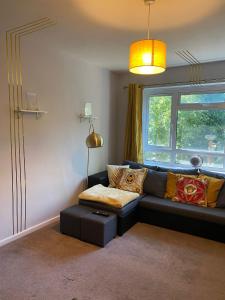 - un salon avec un canapé et une fenêtre dans l'établissement 18K HOME FROM HOME, à Londres