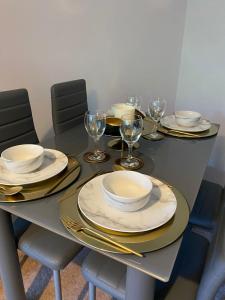 a table with plates and wine glasses on it at 18K HOME FROM HOME in London