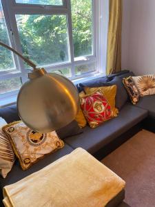 a living room with a blue couch with pillows at 18K HOME FROM HOME in London