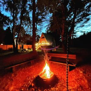 een vuurplaats in het midden van een tuin 's nachts bij Mesa Summer House in Zakrzewo