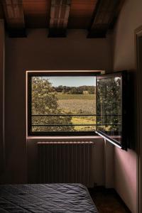a bedroom with a window with a view of a field at Hotel Liberty in Spresiano