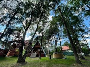 a cabin with a playground in a park with trees at Mesa Summer House in Zakrzewo