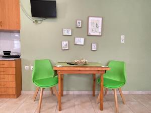 a table and two green chairs in a kitchen at Cactus rooms in Stratoni