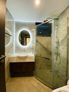 a bathroom with a glass shower and a sink at Căn Hộ Cao Cấp 2 Ngủ Grand Tower in Hai Phong