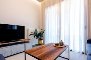 un salon avec une télévision et une table en bois dans l'établissement Agapi's Luxury Apartment, à Pylos