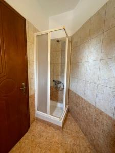 a shower with a glass door in a bathroom at Cactus rooms in Stratoni