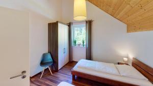 1 dormitorio con 1 cama y 1 silla azul en Villa Vicana, en Kirchbach