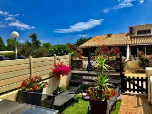 patio z krzesłami i doniczkami oraz dom w obiekcie Naturiste Heliovillage Villa de Standing w Cap d'Agde