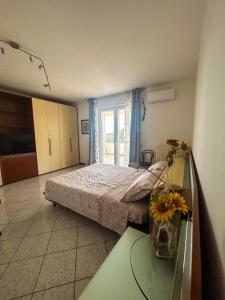 Un dormitorio con una cama y una mesa con flores. en Villa Colle Salento, en Collepasso