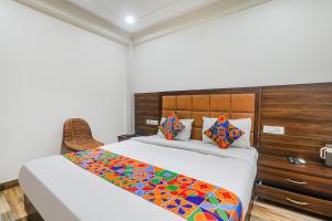 Un dormitorio con una cama con una manta de colores. en FabHotel Bless Inn, en Allahābād
