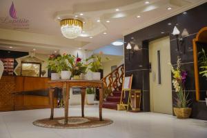 a lobby with a table with potted plants on it at فندق البيت الصغير - Lapetite Maison Hotel in Baghdad