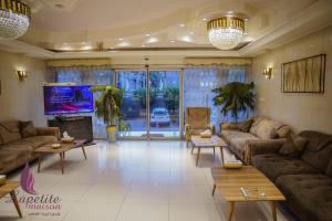 a living room with couches and a flat screen tv at فندق البيت الصغير - Lapetite Maison Hotel in Baghdād