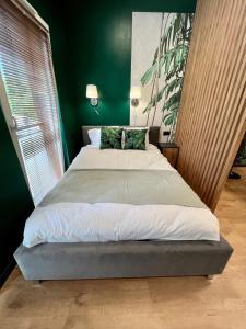 uma cama grande num quarto com paredes verdes em Apartament SPOT Klonowa em Kielce