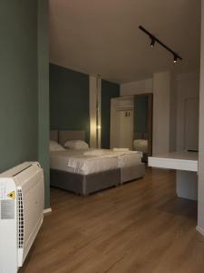 a room with two beds and a fan in it at Capital Suites Center in Tirana