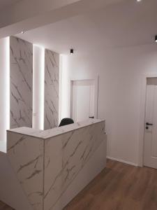 a marble counter in a white room with a door at Capital Suites Center in Tirana