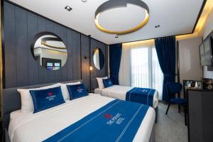 a hotel room with two beds and a mirror at The Private Airport Hotel in Istanbul