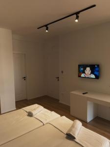 a room with a bed and a tv on the wall at Capital Suites Center in Tirana