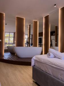 a large bathroom with two beds and a bath tub at Capital Suites Center in Tirana