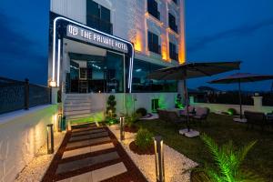 a hotel entrance with tables and umbrellas at night at The Private Airport Hotel in Istanbul