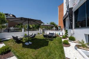 a patio with a table and chairs and an umbrella at The Private Airport Hotel in Istanbul