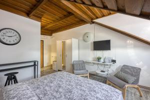 1 dormitorio con 1 cama, 2 sillas y reloj en Wellness Estate Hedonia Near Varaždin - Happy Rentals en Majerje