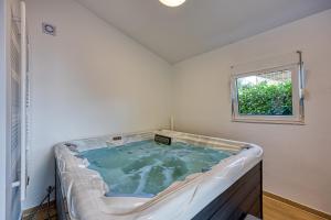 a hot tub in a room with a window at Wellness Estate Hedonia Near Varaždin - Happy Rentals in Majerje