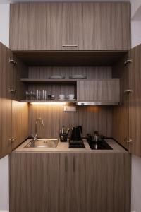 uma cozinha com armários de madeira e um lavatório em ELITE APARTMENTS em Tessalônica