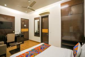 una camera con letto, scrivania e TV di FabHotel Rivlet Residency a Gurgaon
